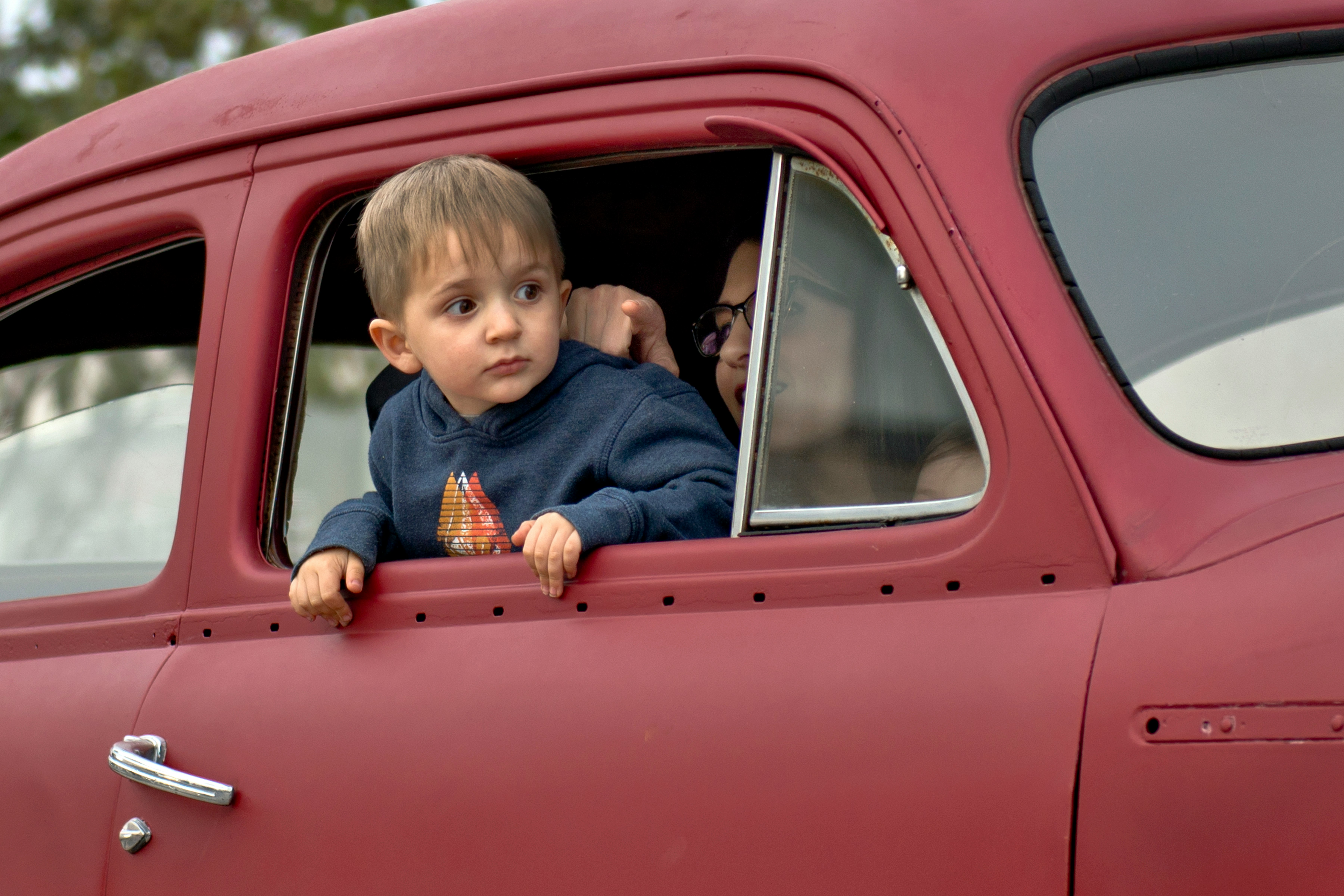 toddler riding on red vehicle